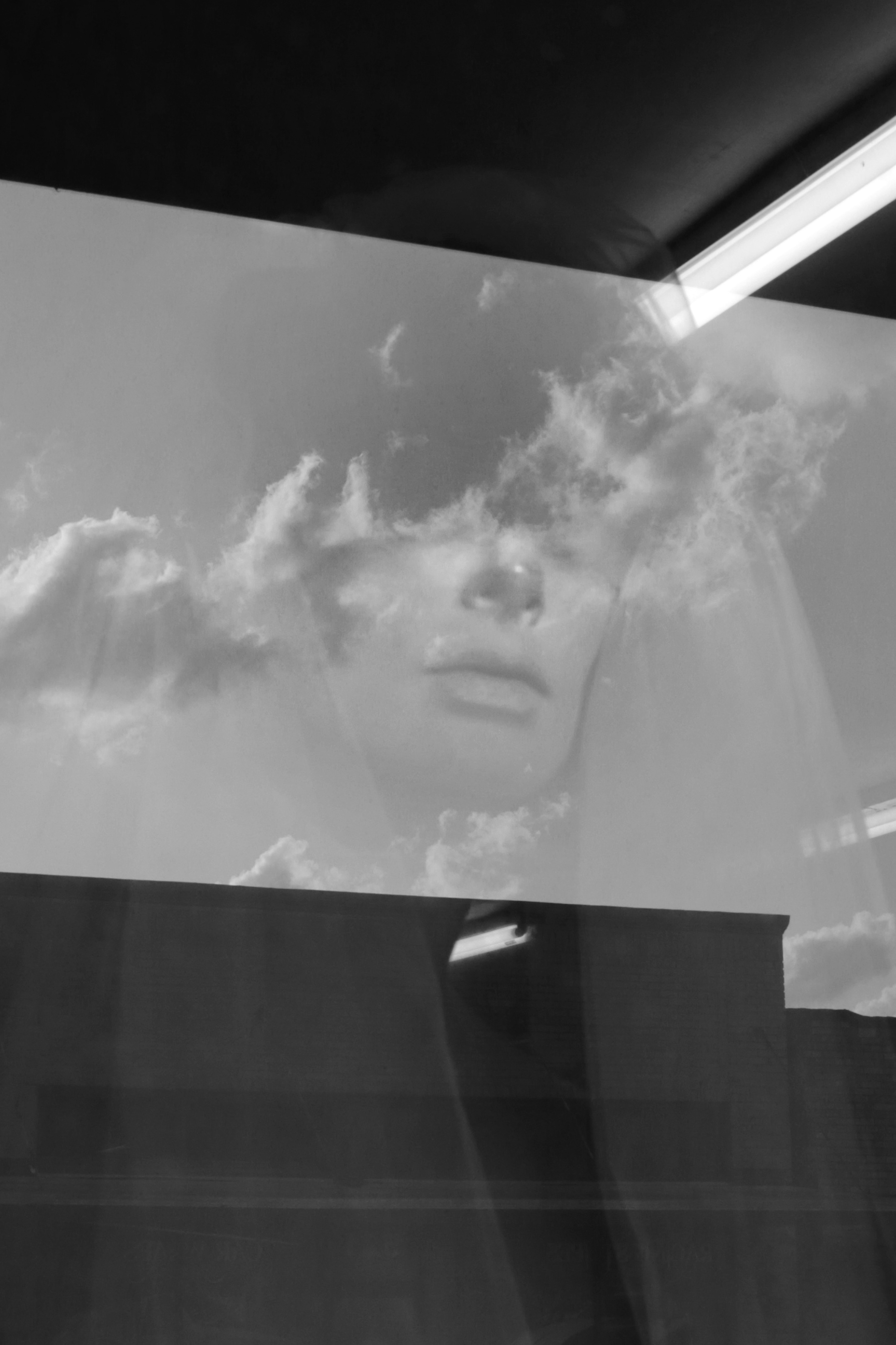 Double exposure black and white portrait with clouds.