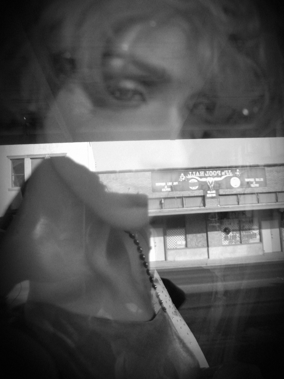 Double exposure black and white photograph of a street scene.